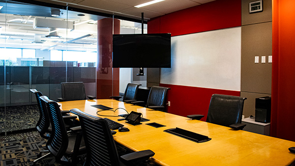 Vision room conference table and seating, facing screen.