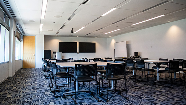 Discovery room set up with 2 table stations with monitors on the walls