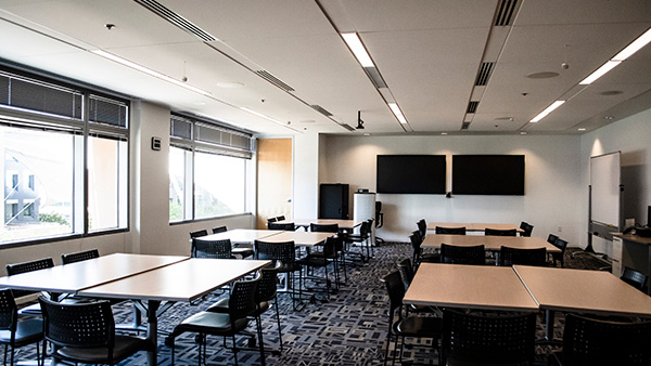 Discovery room set up with 2 table stations with monitors on the walls