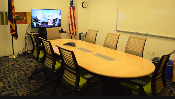 Acceleration boardroom from end of conference table with chairs and monitor on the wall.