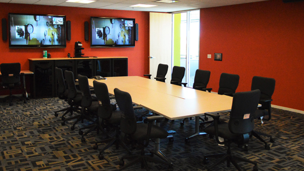 Alliance room set up as a conference room table with monitors on wall.