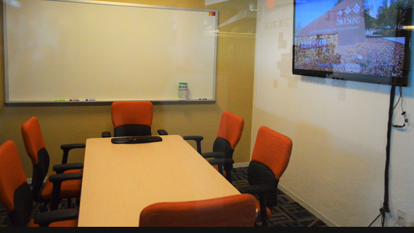 Collaboration room table and chairs with screen and monitor on walls
