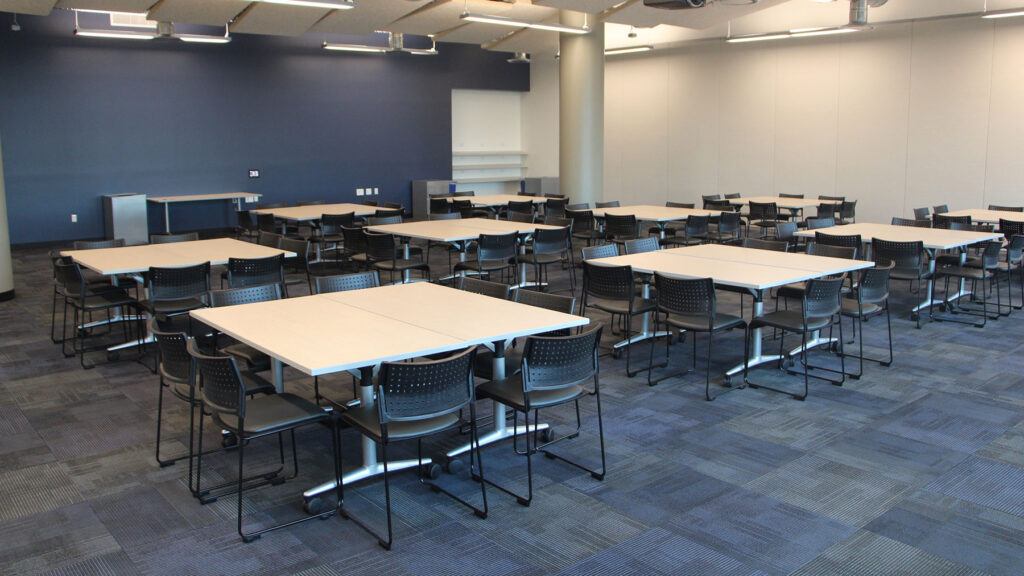 Synergy II room set up as square tables seating 8, with 10 sets.